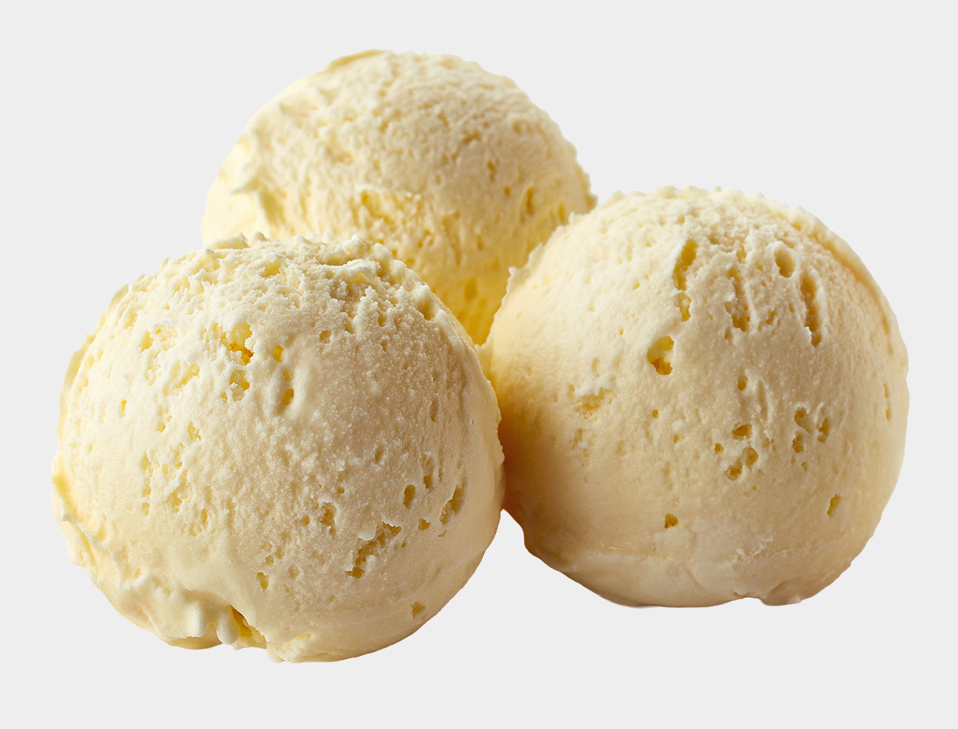 Three scoops of creamy vanilla ice cream on a light background.