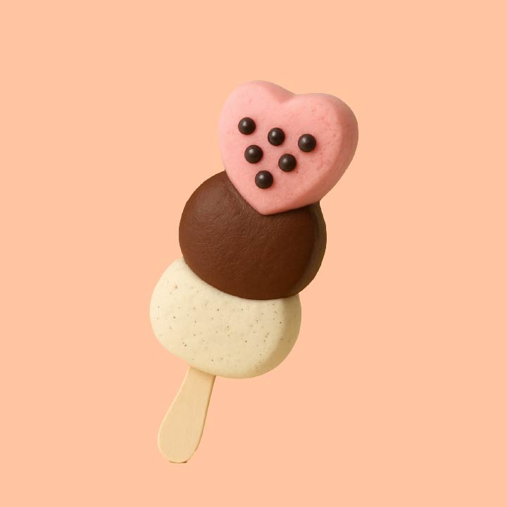 Three-flavor ice cream pop with a vanilla scoop, chocolate scoop, and a pink heart-shaped scoop topped with chocolate chips.